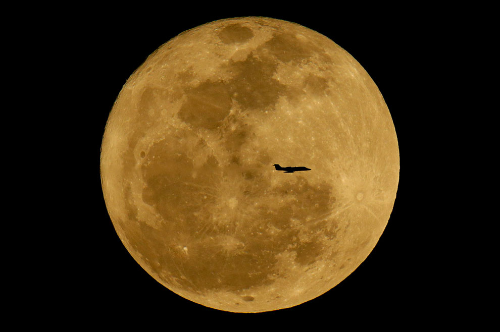 Самолет на фоне восходящей Луны