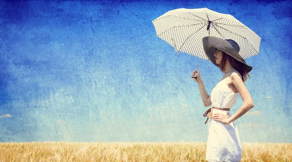 Женщины с зонтиком в поле пшеницы — стоковое фото