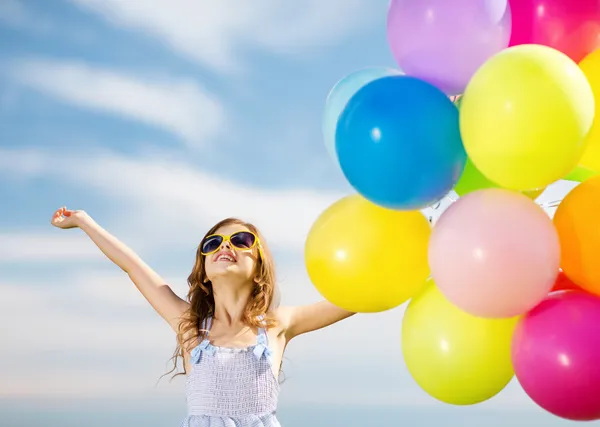 Счастливая девочка с красочными воздушными шарами — стоковое фото