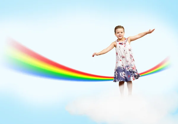 Девочка прыгает на облака и Радуга — стоковое фото