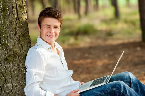Портрет мальчика подростка с ноутбуком — стоковое фото