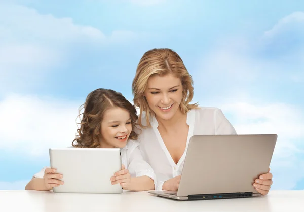 Мать с девочкой, обращающейся к ноутбуку и PC таблетки — стоковое фото
