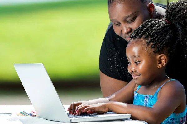 Африканские матери, помогая парень на ноутбуке — стоковое фото