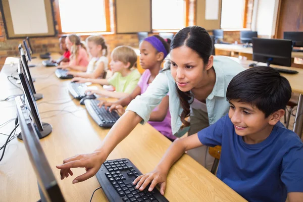 Симпатичные учеников в компьютерном классе с учителем — стоковое фото