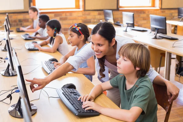 Симпатичные учеников в компьютерном классе с учителем — стоковое фото