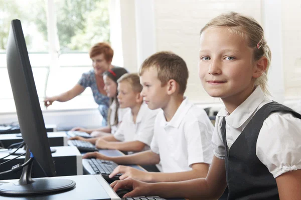 Группы элементарных учащихся в компьютерном классе с учителем — стоковое фото