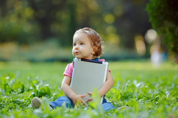 Ребенок, играя с планшета на открытом воздухе — стоковое фото