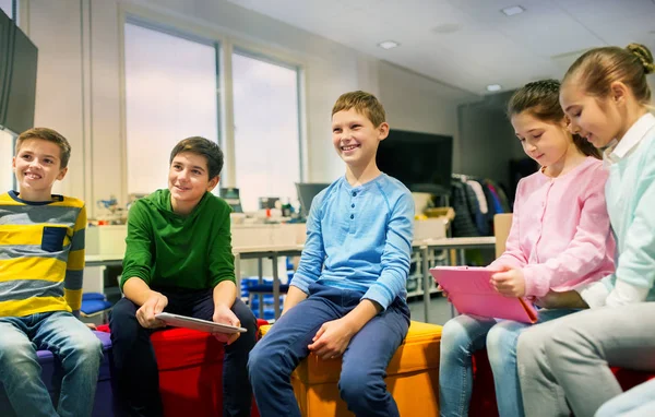 Группа счастливых детей с планшетных ПК в школе — стоковое фото