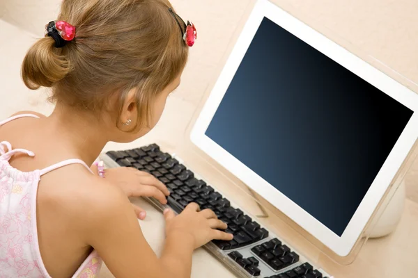 Маленькая девочка, ввода текста на компьютере — стоковое фото