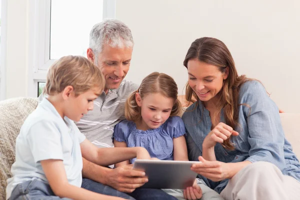 Счастливая семья с помощью планшетного компьютера — стоковое фото