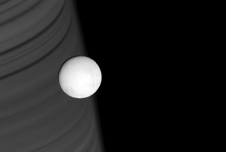 Ледяная луна Энцелад на фоне колец Сатурна