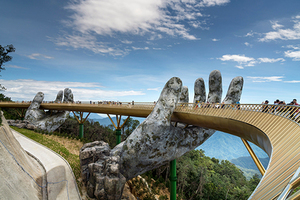 The Golden Bridge is lifted by two giant hands in the tourist resort on Ba Na Hill in Danang, Vietnam. Ba Na Hill mountain resort is a favorite destination for tourists