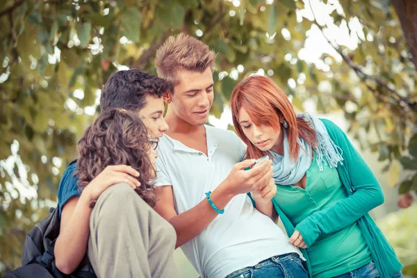 Группа несовершеннолетних друзей с мобильным телефоном — стоковое фото