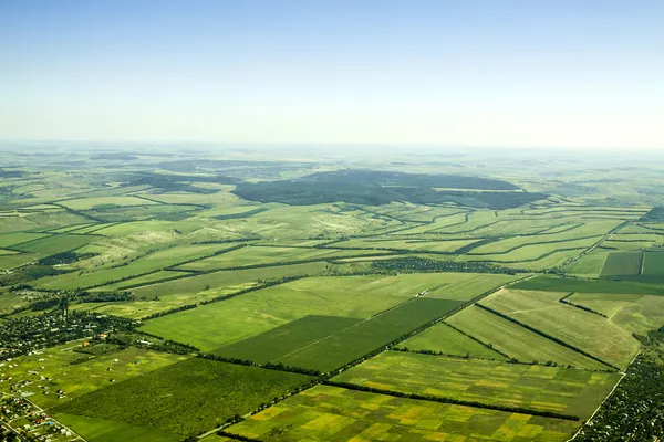 Аэрофотоснимок зеленой сельской местности под голубым небом — стоковое фото