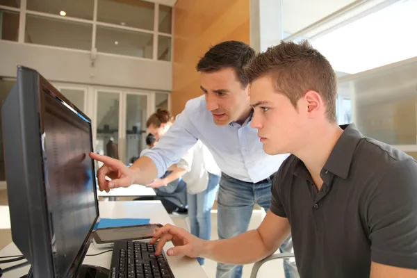 Учитель и студент, работающий над компьютером — стоковое фото