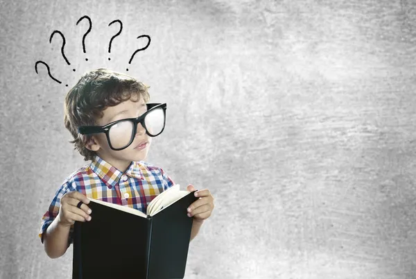 Ребенок с книгой, ища ответы — стоковое фото