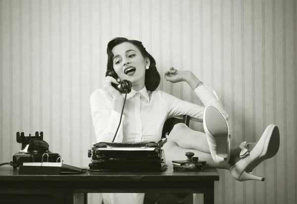 Женщина, говоря на телефоне на стол — стоковое фото