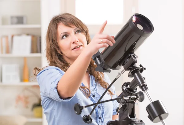 Красивая женщина с телескопом — стоковое фото
