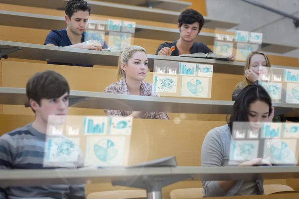 Основное внимание студентов в лекционном зале работает над их Футуристический планшетный — стоковое фото