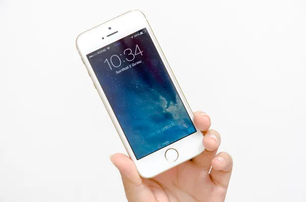 Рука золото iPhone 5s — стоковое фото