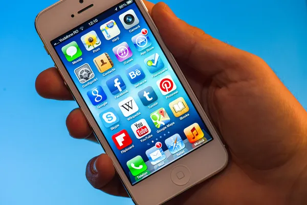 Освещенные приложения iphone 5 держатся в руке — стоковое фото