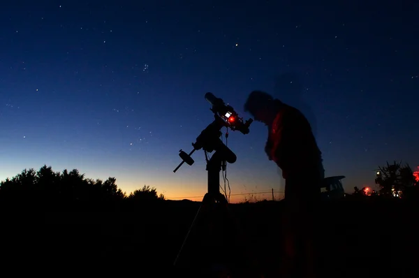 Астроном, смотрит через телескоп — стоковое фото