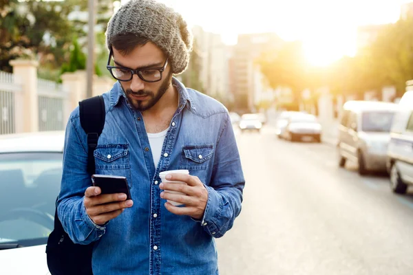 Современный молодой человек с мобильным телефоном на улице — стоковое фото