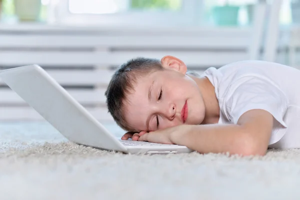 Мальчик спит рядом и ноутбук — стоковое фото