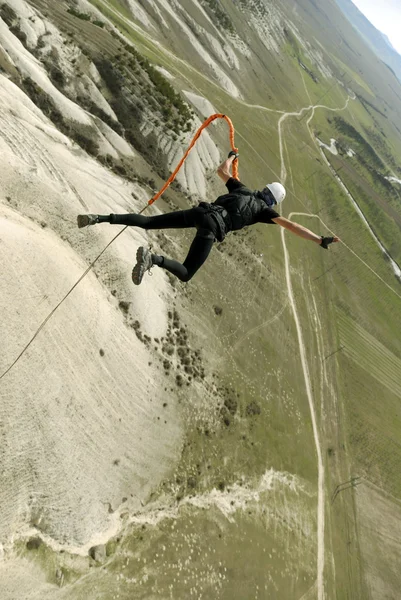 Прыгать с обрыва в каньон с веревкой — стоковое фото