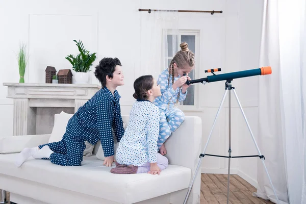 Дети, играющие с телескопом — стоковое фото
