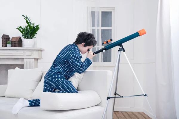 Маленький мальчик смотрит через телескоп — стоковое фото