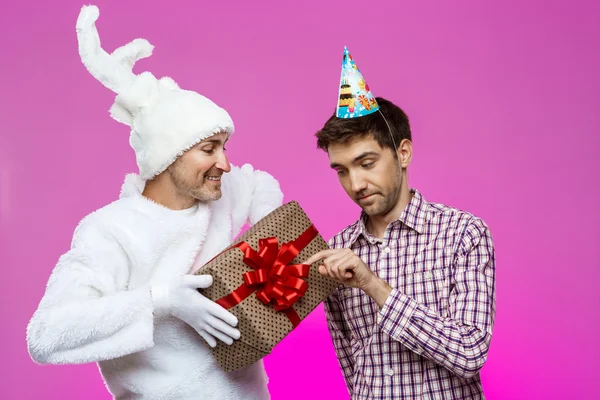 Кролик, давая подарок на день рождения пьяный человек на фиолетовом фоне — стоковое фото