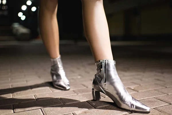 Cropped Shot Woman Glossy Silver Boots Walking Street Night — стоковое фото