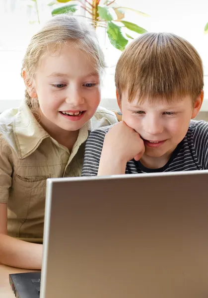 Школа мальчик и девочка портрет, глядя на ноутбук — стоковое фото