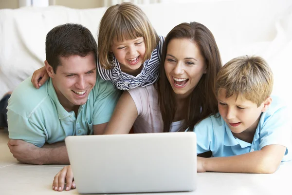 Молодые родители с детьми, на портативном компьютере — стоковое фото
