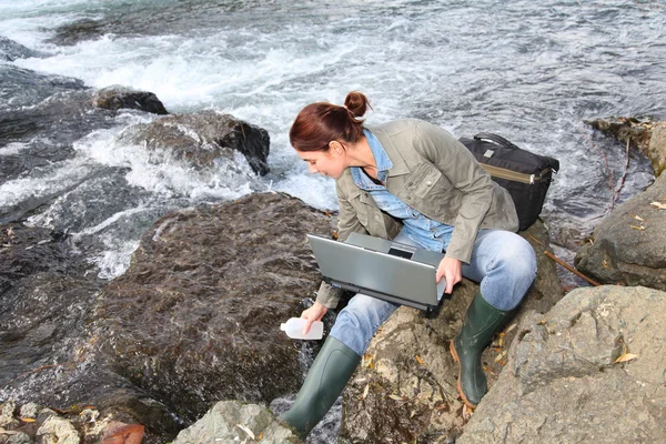Исследовательница делает испытание качества воды в реке — стоковое фото