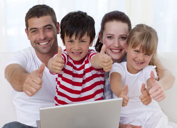Семьи на дому с помощью ноутбука с большими пальцами руки — стоковое фото